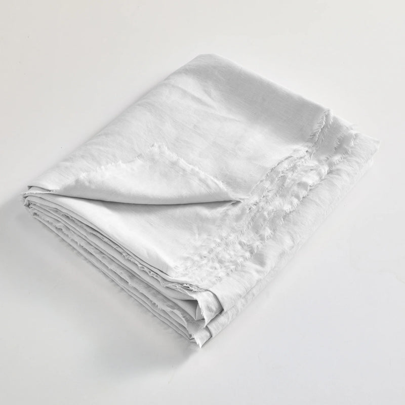 drap plat en lin lavé effrangé plié blanc